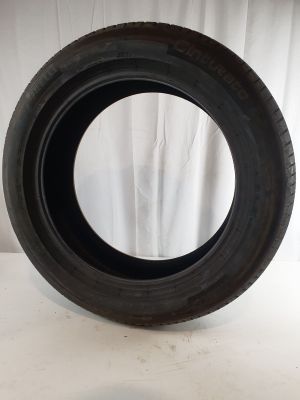 a close up of a tire on a white surface with a white curtain in the background