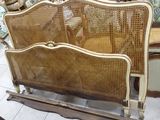 a bed with a wooden frame and wicker headboard