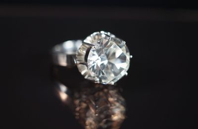 Gros plan sur une bague en diamant posée sur une surface brillante