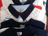 a lot of t - shirts that are sitting on a table