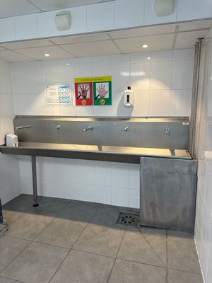 un grand lavabo en acier inoxydable dans des toilettes publiques