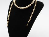 un gros plan d'un collier orné de perles porté par un mannequin