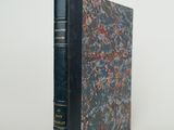 un livre à la couverture noire posé sur une table blanche