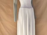 le mannequin porte une robe blanche et est posé sur un socle