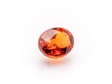 a close up of an orange sapphire stone on a white background