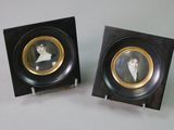 two framed pictures of a man and a woman on display