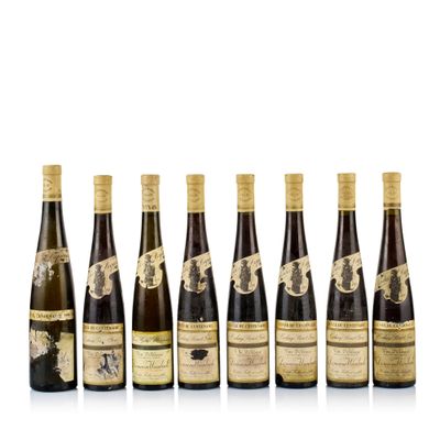 six bottles of wine lined up in a row on a white surface