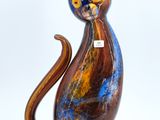a colorful cat figurine sitting on a white surface