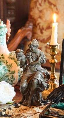 une table sur laquelle se trouvent un vase, une bougie, un cadre et une photo