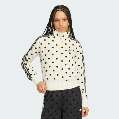une femme portant une veste à pois et un pantalon noir