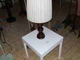 une table blanche sur laquelle est posée une lampe, dans un salon