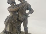 a bronze statue of a man and a woman holding each other