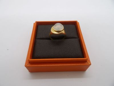une boîte orange contenant une bague, posée sur une surface blanche