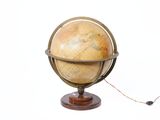un petit globe terrestre posé sur un socle en bois, sur fond blanc