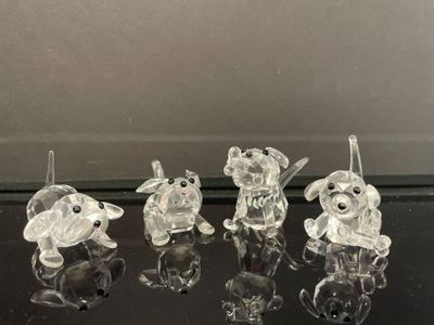 cinq figurines d'animaux en verre transparent posées sur une table