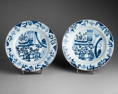 pair of blue and white plates with figures and flowers