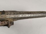 an old gun that is on display on a white surface