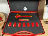 une mallette rouge contenant des outils, posée sur une table