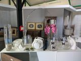 une table sur laquelle sont posés des vases et des assiettes, dans une pièce