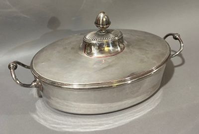 une casserole en argent avec un couvercle, posée sur une table blanche