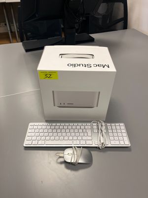 une boîte blanche posée sur une table, avec un clavier et une souris à côté
