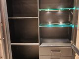 a metal cabinet with glass shelves and drawers in it