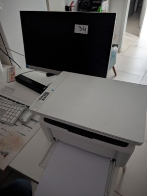 a desk with a computer and a printer on it