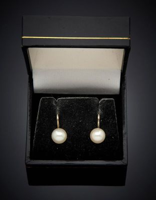 a pair of pearl earrings in a black box