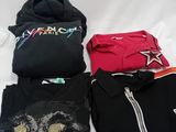 a lot of t - shirts that are on a bed