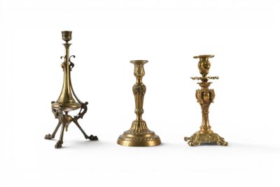 three brass candlesticks are sitting next to each other on a white surface