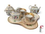 a tea set on a tray with a cup and saucer