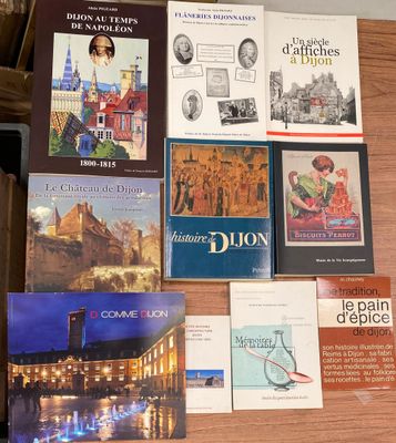 plusieurs livres posés sur une table, sur laquelle se trouve un ordinateur portable
