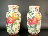 deux vases posés sur une table, sur lesquels sont peints des fleurs