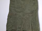 a green skirt hanging on a hanger on a wall