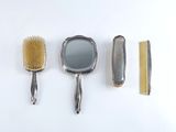 four different types of hair brushes and combs on a white surface