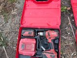 two red tools in a red case on the ground