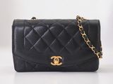 un sac Chanel noir avec des finitions dorées et une chaîne