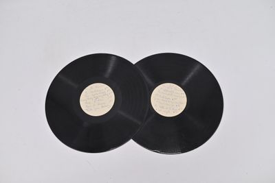 two black vinyl records sitting on top of a white surface