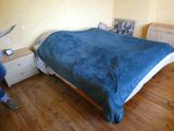 une femme debout près d'un lit dans une chambre à coucher