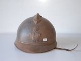 a brown helmet on a white surface with a sticker on it