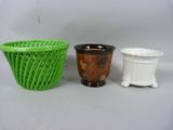 deux vases verts et blancs posés l'un à côté de l'autre sur une table