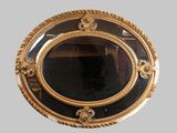 a mirror with a gold frame on the wall