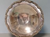 a silver bowl on a table with a blue wall in the background