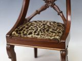 une petite chaise sur laquelle est posé un coussin à motif léopard
