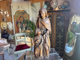 a statue of a woman holding a child in a living room