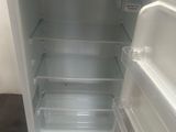 an empty white refrigerator in the corner of a room