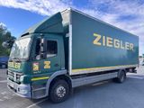 un camion vert garé sur un parking