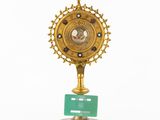 clock on a stand with a green plaque on top of it