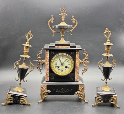 a clock that is sitting on a table next to three vases