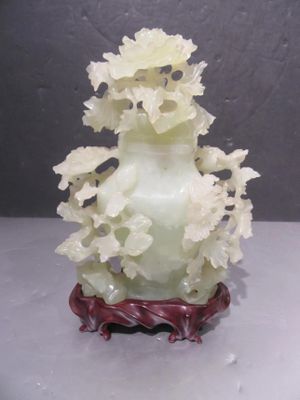 a white vase with flowers in it on a table